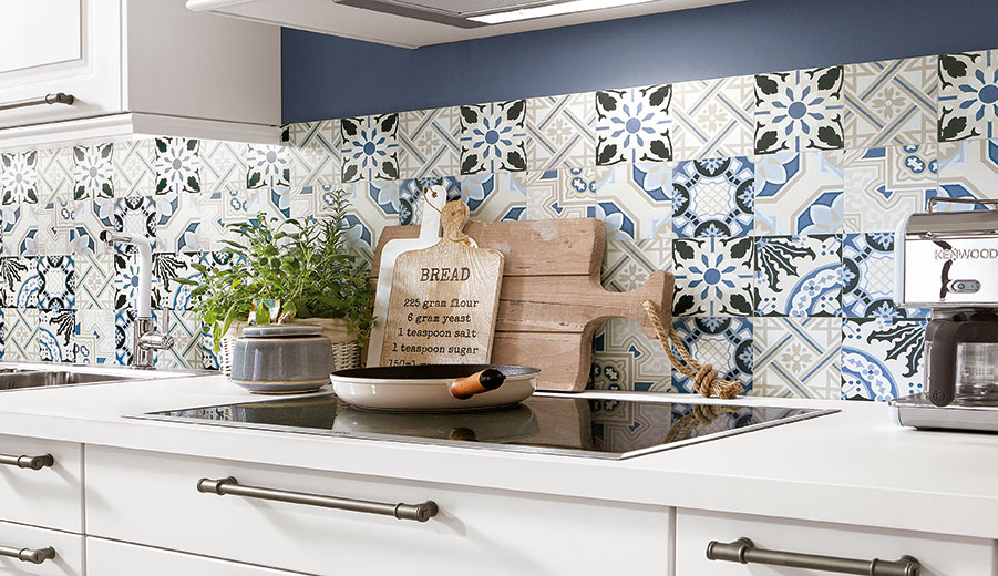Elegant kitchen featuring white cabinetry, marble countertops, and a vibrant blue-patterned backsplash, complemented by modern appliances and rustic wooden accessories.